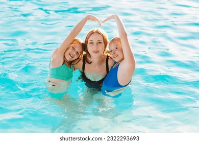 Mom swims in the pool with her two daughters. Holidays with children. Safe games in the water. Mother's love and care. - Powered by Shutterstock