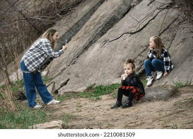 Mom Takes Pictures Of Her Daughters On A Phone Camera On A Walk Outside The City In The Warm Season