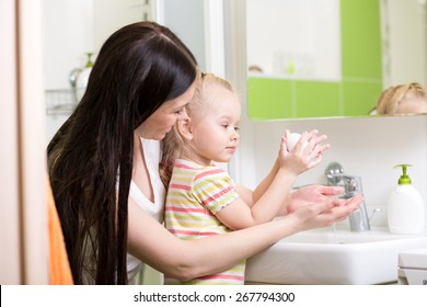 Mom Teaches Child Hands Washing With Soap In Bathroom