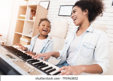 Mom teaches a little girl to play the piano. They play and sing songs. They are having fun. - Powered by Shutterstock