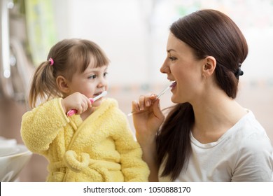 mom teaching daughter child teeth brushing in bathroom - Powered by Shutterstock