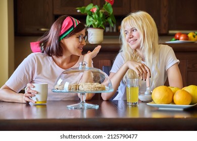 Mom And Teenage Daughter Eating Together, Sitting At Table At Home In Kitchen