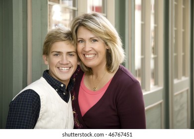 A Mom And Teenage Son Posing Near A Storefront