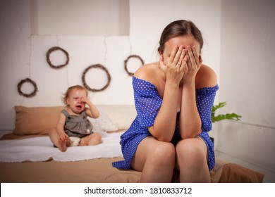 Mom Is Tired Of The Baby, Wants To Rest And Sleep. The Child Screams, Hysterical. The Woman Is Tired Of The Child's Cry, She Does Not Want To Hear. A One-year-old Girl Yells From A Toothache.