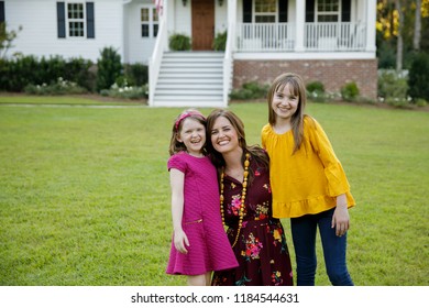 Mom And Two Daughters Being Silly Having Fun Laughing Outside Their Home