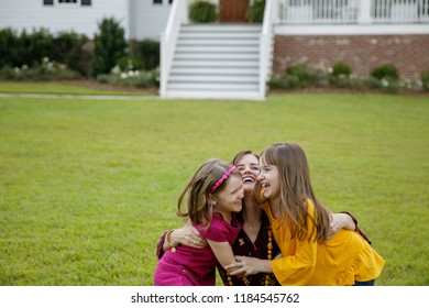 Mom And Two Daughters Being Silly And Laughing Outside Their New Farmhouse Home