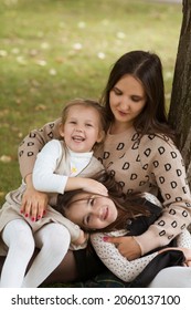 Mom And Two Sisters Child Girls   Embrace, Playing  And  Having Fun Together  Outdoor