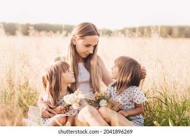 Mom With Two Twin Girls Playing In Nature In The Summer