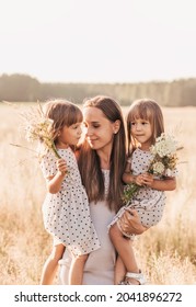 Mom With Two Twin Girls Playing In Nature In The Summer