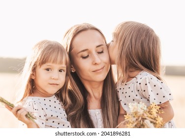 Mom With Two Twin Girls Playing In Nature In The Summer