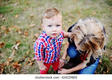 Mom Tying Laces On Shoes Little Son. Mom Teaches Son To Tie Shoelaces. Children's Fashion