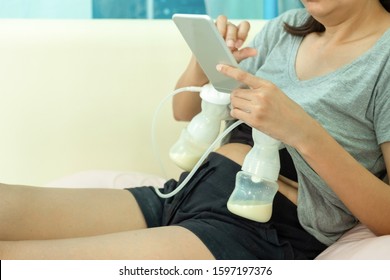 Mom use electric breast pump feeding for her baby with smart phone.