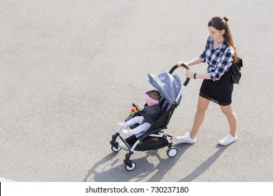 Mom Walks With A Stroller. View From Above