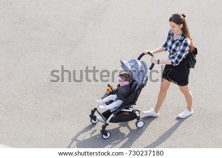 mom walks with a stroller. view from above