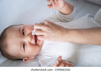 Mom Wipes The Baby's Drool With A Napkin. Baby Care, Teething, Drooling.