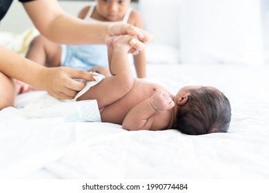 Mom Wiping Her Newborn Baby Skin, Face With Wet Wipes Carefully On Bed At Home. Family, Cleaning Wipe And Infant Concept