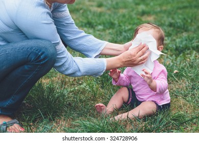 Mom Wiping Nose Her Little Daughter With A Tissue