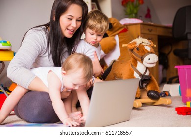 Mom works at a laptop with children