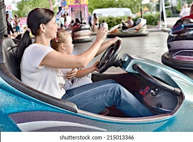 Mom And Young Daughter Ride On The Carousel, Go To A Small Car