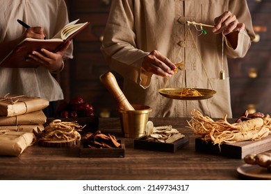 A moment of apocathery measuring ingredient in gold scale with chinese traditional medicine in wooden table 