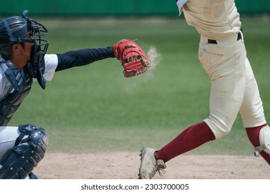 The moment during a baseball game when the pitcher throws and the batter strikes out and the ball lands in the catcher's mitt and a cloud of dust rises. - Powered by Shutterstock