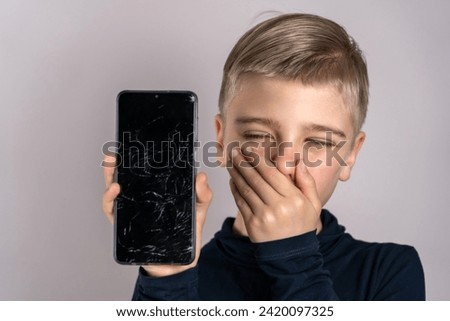 A Moment of Mishap: Young Boy With Broken Smartphone