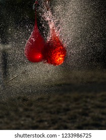 The Moment A Red Ballon Burst In A Dark Backgrounds With Gold Water Droplets Flying Everywhere