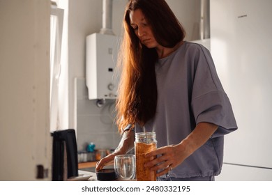 A moment of tranquility as a woman prepares her morning beverage in a sunlit kitchen, enveloped in the days first golden rays - Powered by Shutterstock