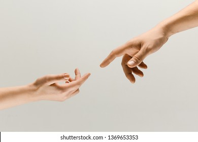 Moment of weightless. Two male hands trying to touch like a creation of Adam sign isolated on grey studio background. Concept of human relation, community, togetherness, symbolism, culture and history - Shutterstock ID 1369653353