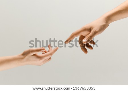 Moment of weightless. Two male hands trying to touch like a creation of Adam sign isolated on grey studio background. Concept of human relation, community, togetherness, symbolism, culture and history 商業照片 © 