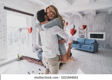 Moments of intimacy. Beautiful young couple embracing and smiling while spending time in the bedroom - Shutterstock ID 1021844062