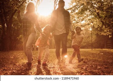 Moments That You Wish Will Last Forever. Happy Family Walking Together Trough Park.