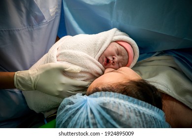 Mommy And Baby Newborn In The Cesarean Section. First Day Of Little Baby Newborn Life  In This World. First Sight Of Mom And Her Newborn In Operation Room