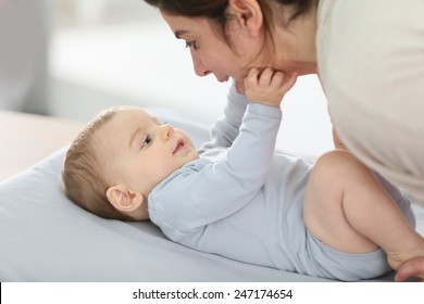 Mommy Cuddling Baby Boy On Changing Table