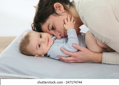 Mommy Cuddling Baby Boy On Changing Table