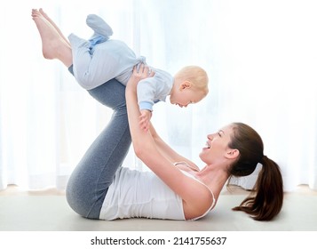 Mommy And Me Exercises. Shot Of A Young Woman Working Out While Spending Time With Her Baby Boy.