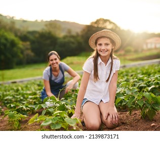 Mommys Teaching Me How To Run This Farm. Portrait Of A Young Girl Working On The Family Farm With Her Mother In The Background.