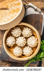 Momo dumplings in a bamboo steamer. Wooden background. Top view