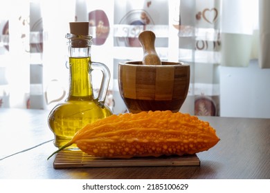 Momordica charantia on the table with olive oil and wooden mortar. - Bitter Melon- balsam pear. Karela. Kudret Nari - Potency Pomegranate - Shutterstock ID 2185100629