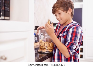 Moms Biscuits Are The Best. A Young Boy Reaching For A Cookie From The Jar.