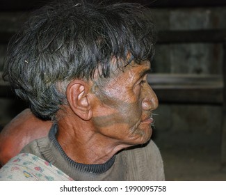 Mon district, Nagaland, India - 03 02 2009 : Closeup indoor profile portrait of old Naga Konyak tribe head hunter warrior with traditional facial tattoo