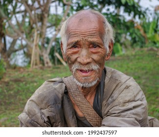 Mon district, Nagaland, India - 03 02 2009 : Outdoor front portrait of smiling old Naga Konyak tribe head hunter warrior with traditional facial tattoo on nature background