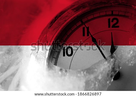 Monaco, Monacan flag with clock close to midnight in the background. Happy New Year concept