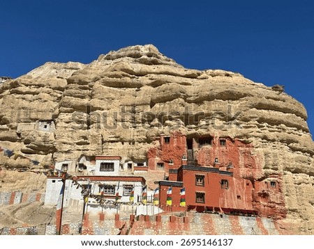 Monastery built into a cliffside in Upper Mustang, a remote region of Nepal. This area, often referred to as the 