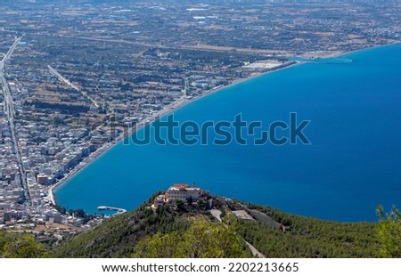 Monastery  of Prophet Elias  on top of a hill with the coastline of Loutraki town, Corinthian bay, Greece ,in the background. Sunny summer day. View from saint patapios monastery