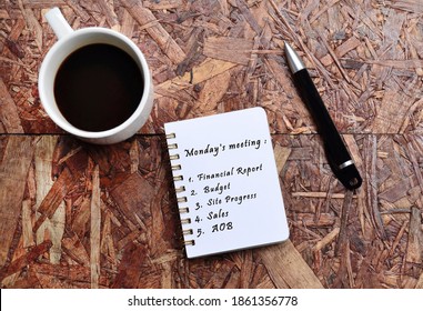 Monday Meeting List Text On Note Pad With Background Of Cup Of Coffee And A Pen. Quote For Monday