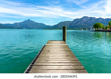 Mondsee with mountains vier from a wooden rustic dock pier .