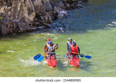 MONDY, BURYATIA, TUNKINSKIY DISTRICT, RUSSIA -  September 22, 2019: Group of tourists is rafting on red rubber catamaran along Irkut mountain river at sunny day. Concept of active pastime in team 