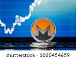 MONERO (XMR) cryptocurrency; silver monero coin on the background of the chart
