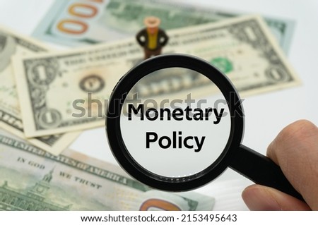 Monetary Policy.Magnifying glass showing the words.Background of banknotes and coins.basic concepts of finance.Business theme.Financial terms.
